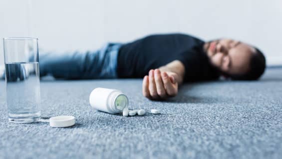 selective-focus-of-unconscious-man-lying-on-grey-f-GJKV8HA